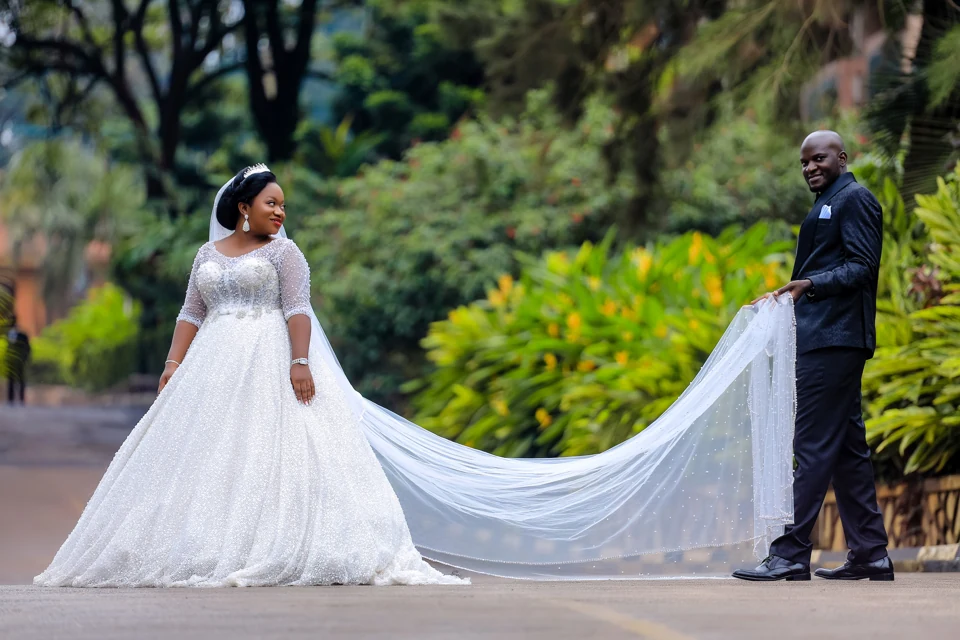 Bride and groom holding the train of a wedding dress in a garden